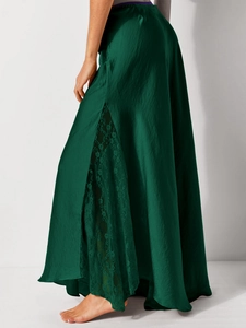 Detail of dark green satin midi skirt with side slit and delicate lace stitching
