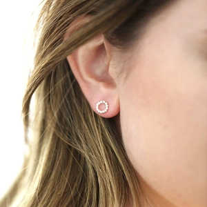 Elegant silver open circle stud earrings with pavé crystals worn by a female model