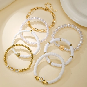 Detailed shot of bohemian beaded bracelets set with gold chains and smiley charms