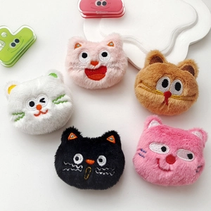 Close-up of colorful plush cartoon cat brooches with polka dots and embroidery detail