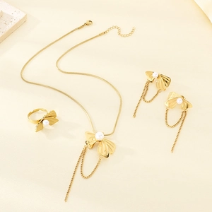 Detailed view of gold bow-shaped jewelry set with pearls and elegant fringe tassels