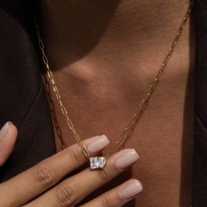 Detail of 18K gold stainless steel paperclip necklace with emerald-cut white zircon charms