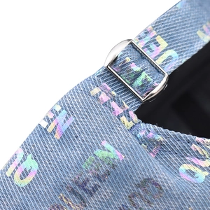 Dettaglio del cinturino regolabile su cappello in denim blu con scritta QUEEN olografica