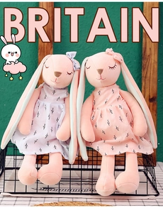 Detailed view of plush bunny toys in pink and purple floral dresses inside a wire basket