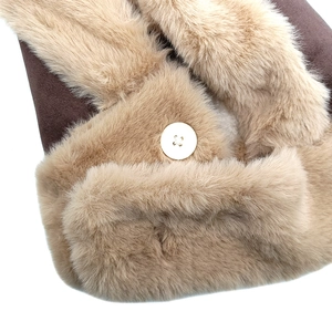 Dettaglio del cappello invernale in pelle scamosciata marrone con pelliccia e bottone