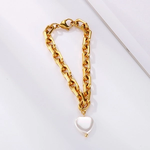 Makroaufnahme von Goldgliederarmband mit Herz-Perlenanhänger und Karabinerverschluss