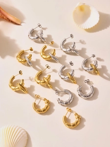Detailed view of C-shaped geometric spiral earrings in gold and silver mixed finishes