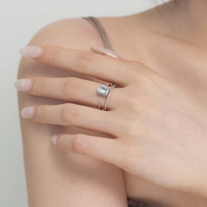Close-up of S925 sterling silver ring with emerald cut zircon stone on model's finger