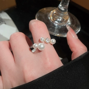 Close-up of a gold vintage ring featuring two elegant pearls and a sparkling zircon stone
