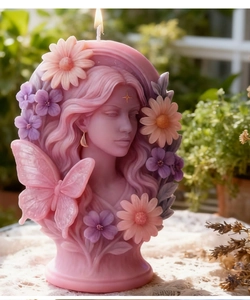 Detail of butterfly fairy candle mold with intricate floral relief and pink butterfly