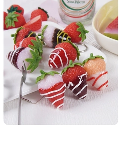 Close-up of assorted artificial strawberry pendants with glazed frosting and metal hooks