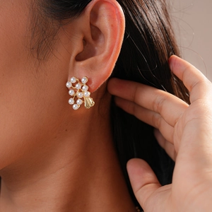 Detail of vintage gold branch earrings with pearls worn by model in a profile view