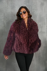 Detailed texture of burgundy faux fox fur coat with oversized fluffy lapels and plush finish