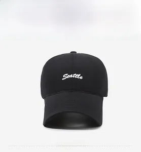 Close-up of black cotton baseball cap featuring white Seattle embroidery on the front