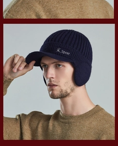 Detail of dark blue knit winter hat with earflaps and Sport embroidery worn by a model