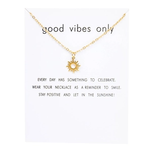 Detailed view of a gold sun pendant necklace on a minimalist decorative display card