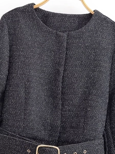 Detail of tweed jacket texture with matching belt and decorative golden square buckle