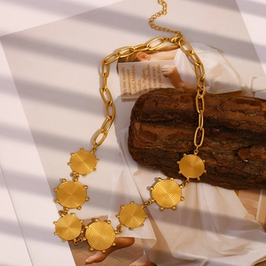 Detailed close-up of retro 18K gold plated stainless steel spiral pendant necklace on a prop