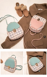 Detail of mint green and pink mini backpacks with metal clasps and plaid fabric texture