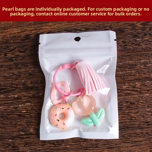 Detail of tulip resin keychain set with pink tassel and donut charm in pearl bag