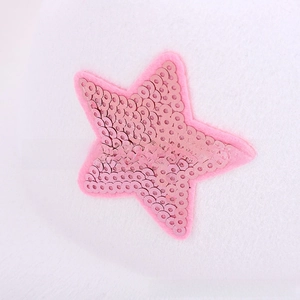 Detailed view of pink sequin star patch on white felt fabric for western cowboy hat