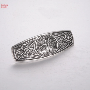 Macro detail of vintage silver Tree of Life hair clip with Celtic knot embossed patterns