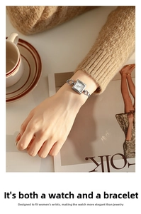 Elegant silver square watch with chain strap styled with a coffee cup and magazine