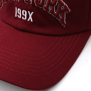 Close-up of burgundy cotton baseball cap featuring precise 199X embroidery and stitching