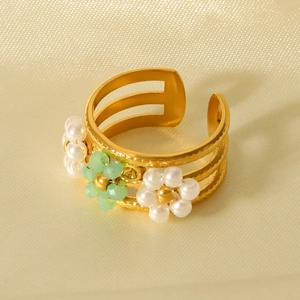 Detail of adjustable gold ring with small white pearls and light green floral beads
