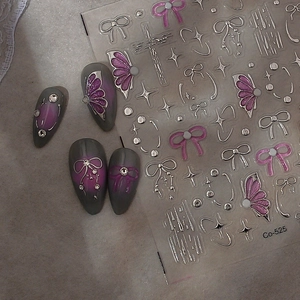 Close-up of 5D metallic bow and star nail stickers on pink gradient manicure