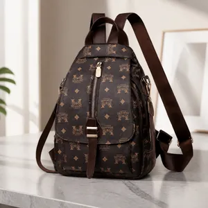 Detail von Monogramm-Muster und Magnetschließe am braunen Nylon-Pendler-Rucksack