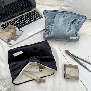 Macro shot of embossed velvet cosmetic bag showing thick texture and zipper detail