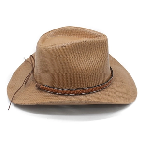 Detail of woven straw cowboy hat with wide brim and decorative leather style band