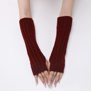 Macro shot of dark red cable knit arm warmers with detailed braided pattern and fingerless design