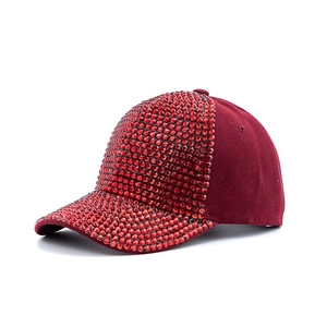 Close-up of sparkling red rhinestones on the brim and front of a burgundy baseball cap