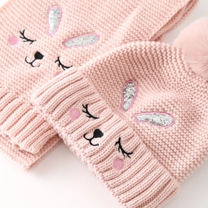 Close-up of pink knit hat with sequined bunny ears and soft faux fur pom-pom detail