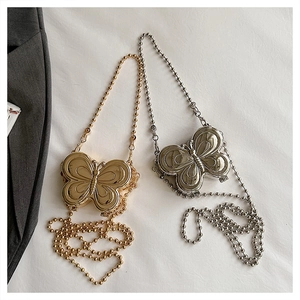 Detailed close-up of gold and silver butterfly metal mini crossbody bags with bead chains