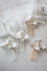 Macro detail of white ceramic flower and freshwater pearl hair combs for wedding accessories