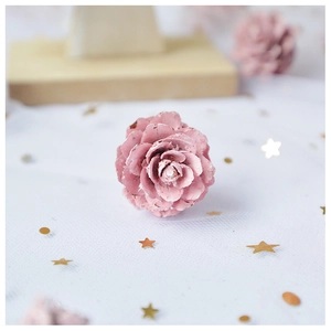 Macro shot of delicate pink pinecone flower decoration with soft layered petals and gold sequins