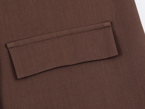Detailansicht der braunen Köperbindung und rechteckigen Taschenklappe am Blazer