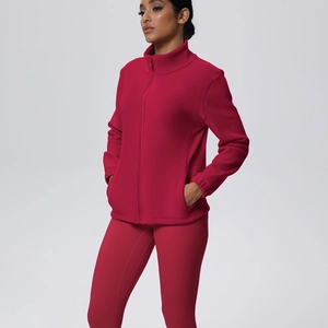Dettaglio di un completo da yoga rosso scuro con giacca con zip e leggings sportivi