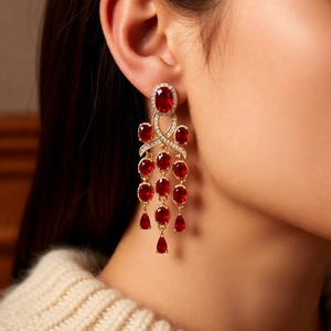 Close-up of luxury red gemstone tassel earrings with gold plating and zircons