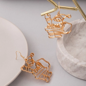 Gros plan de boucles d'oreilles de Noël dorées avec Père Noël et renne sur un porte-bijoux