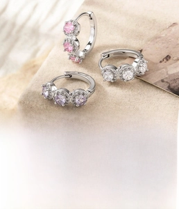 Macro detail of copper earrings set with pink, purple, and white cubic zirconia crystals