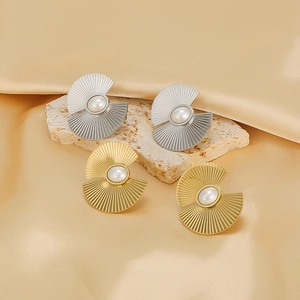 18k gold plated fan-shaped pearl stud earrings on natural stone and silk background