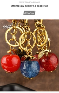 Detail view of colorful apple keychains in red, blue, and black with golden metal clasps