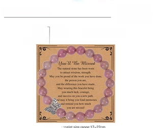 Detail of 8mm pink zebra stone bracelet with silver butterfly charm on a kraft gift card