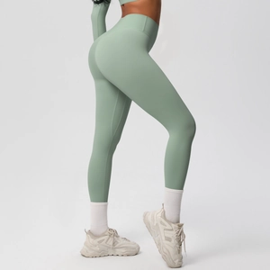 Macro detail of high-waisted yoga leggings in light green with seamless butt-lifting seams