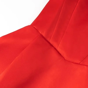 Detail of red tube dress showing precise V-shaped stitching and structured satin fabric texture