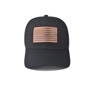 Vista frontale di un cappello nero in rete con toppa in pelle della bandiera americana